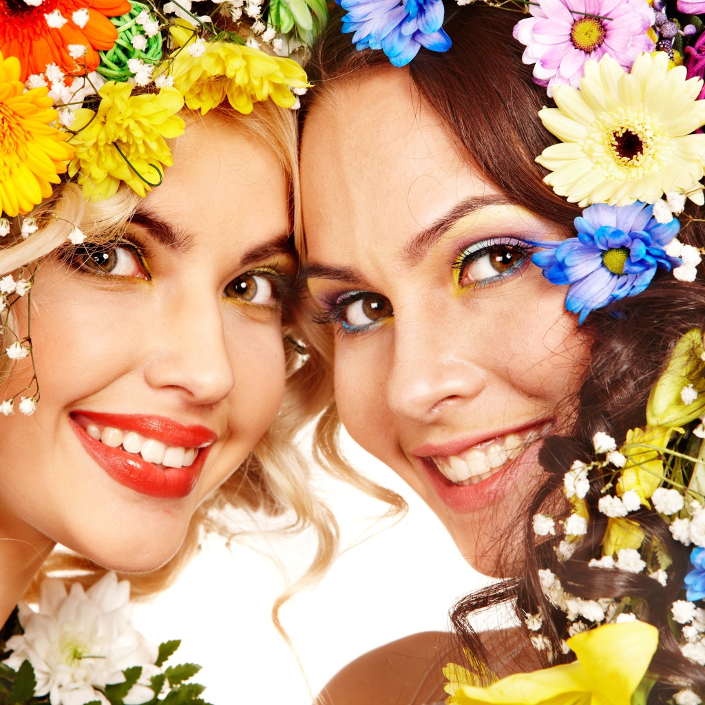 Две яркие улыбающиеся девушки с цветами в волосах 