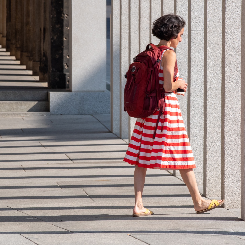 Женщина в красном полосатом платье с рюкзаком