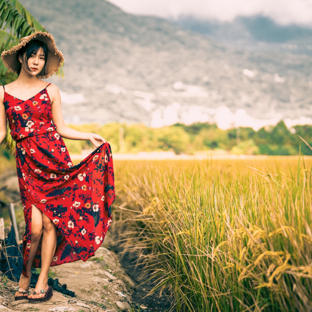 Молодая азиатка в сарафане на рисовом поле 
