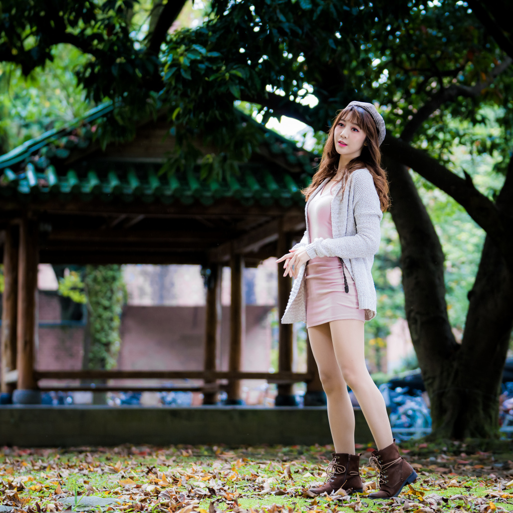 Молодая азиатка в теплой кофте в парке