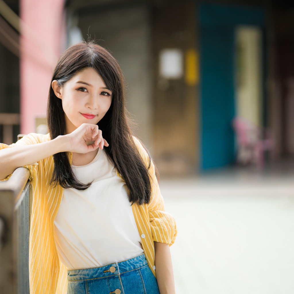 Молодая азиатка в белой майке и полосатой рубашке 