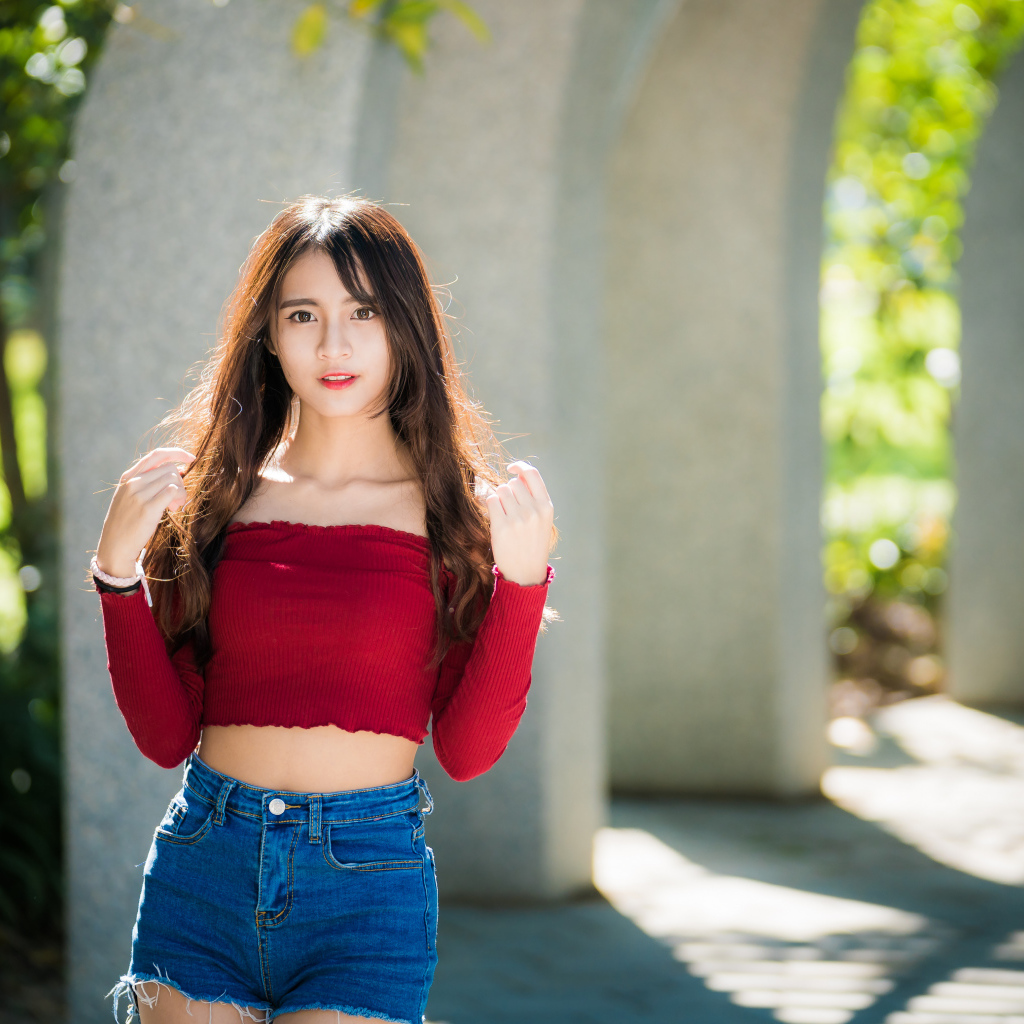 Молодая азиатка с коротких джинсовых шортах