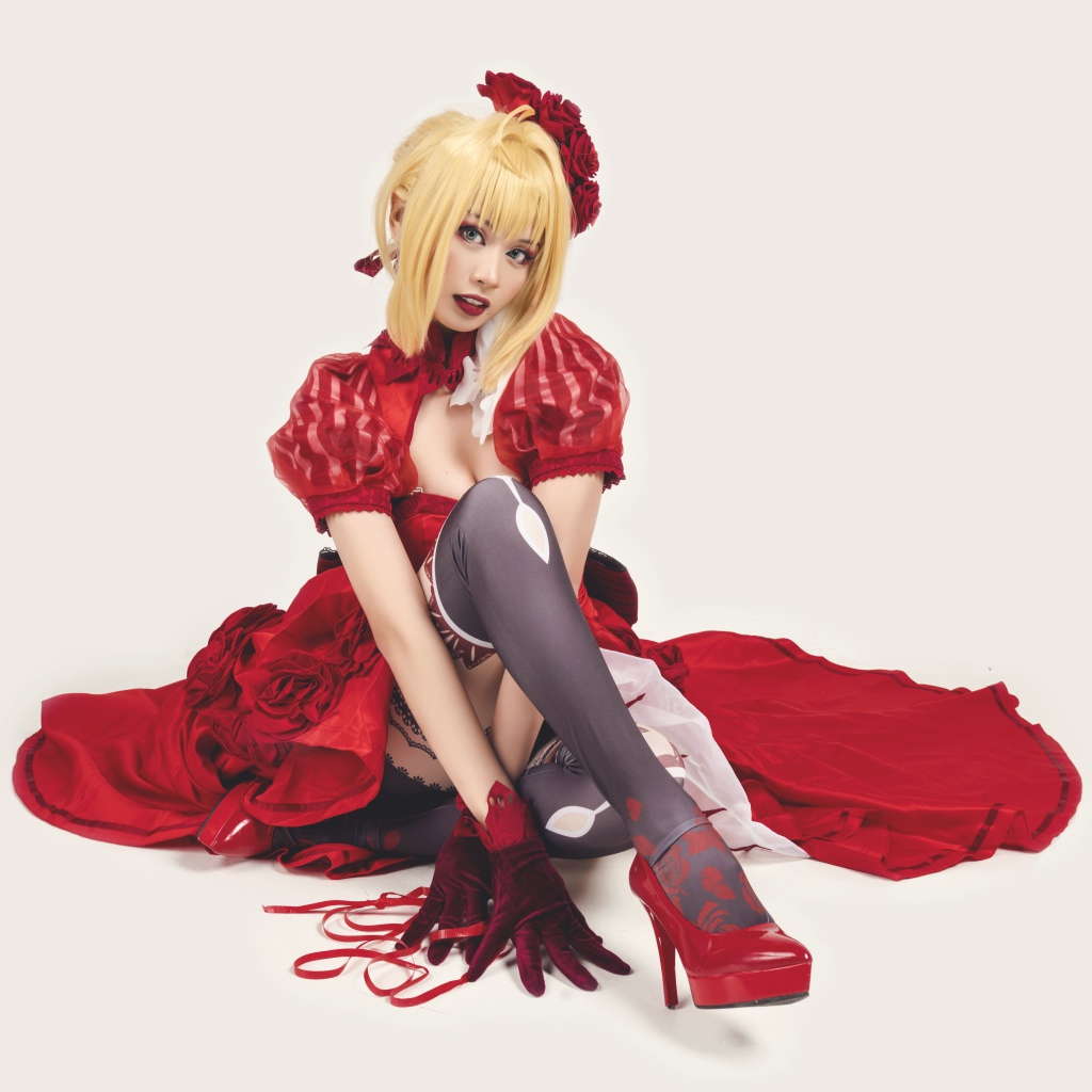 Молодая азиатка в ярком красном костюме на белом фоне