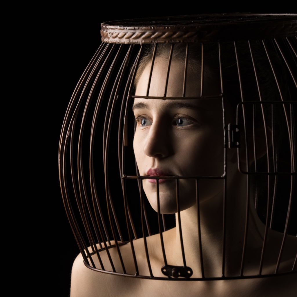 Молодая девушка с клеткой на голове 