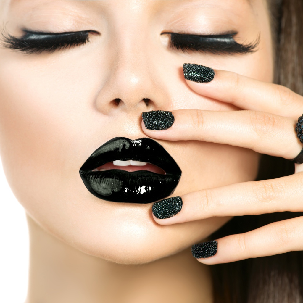 Молодая девушка с черным макияжем на белом фоне