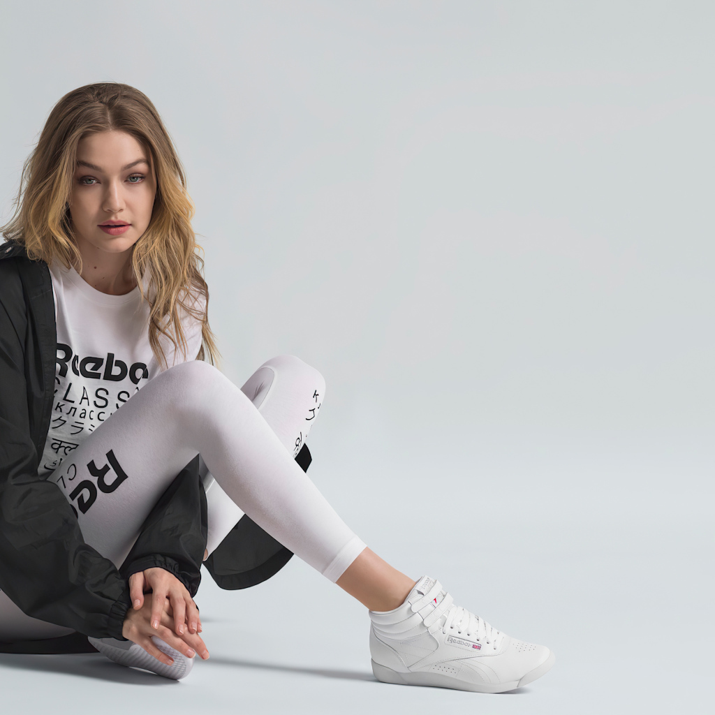 Американская супермодель Джиджи Хадид в спортивном костюме сидит на полу