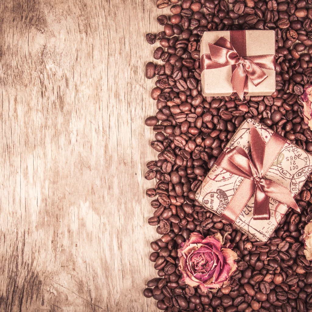 Подарки и розы лежат на кофейных зернах