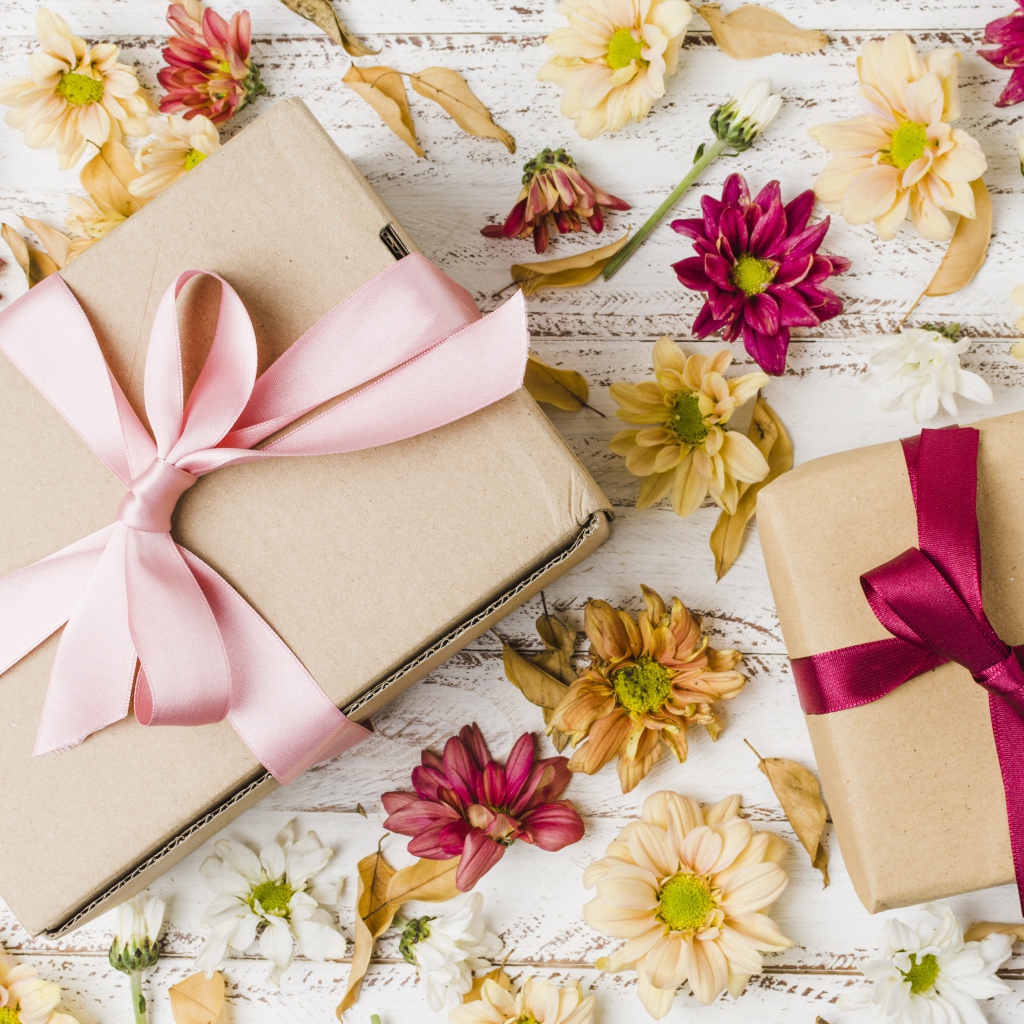 Две коробки с подарками на столе с цветами хризантемы