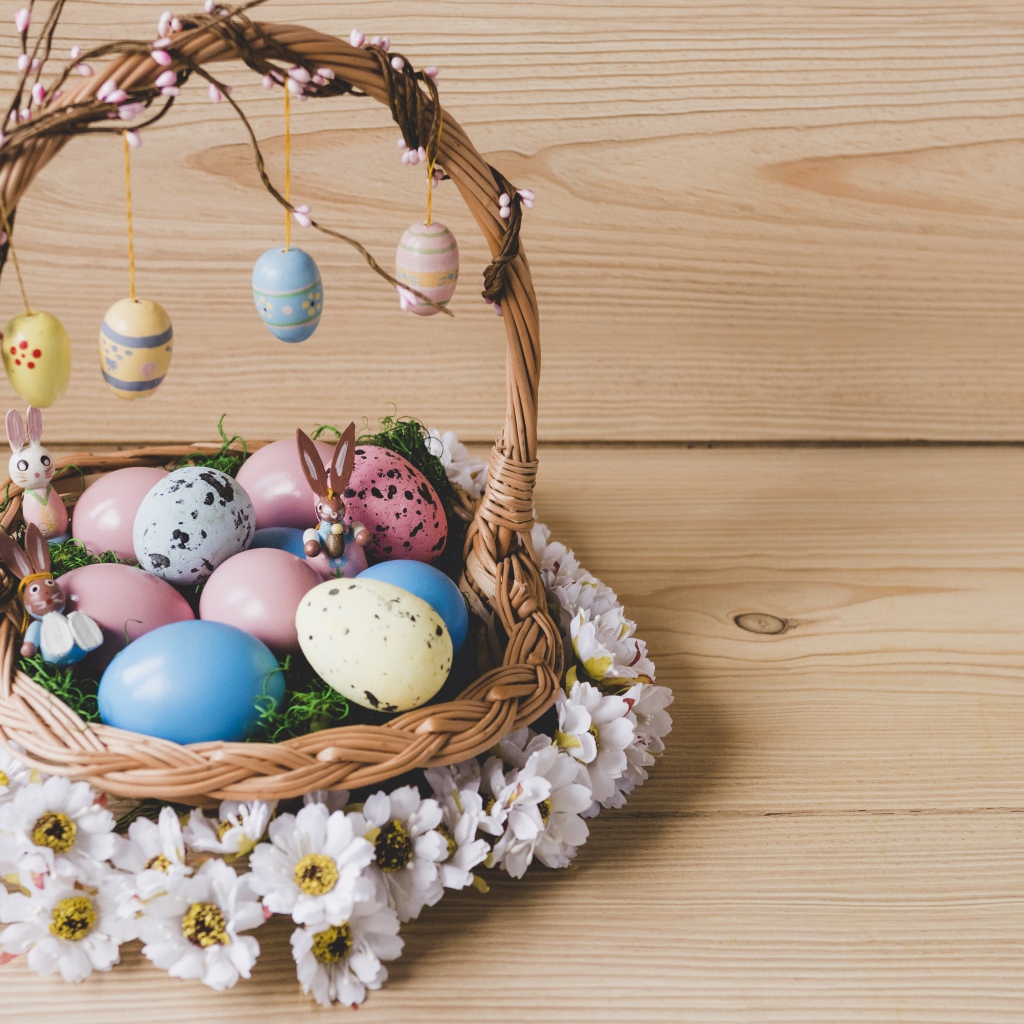 Корзинка с пасхальными яйцами украшена цветами