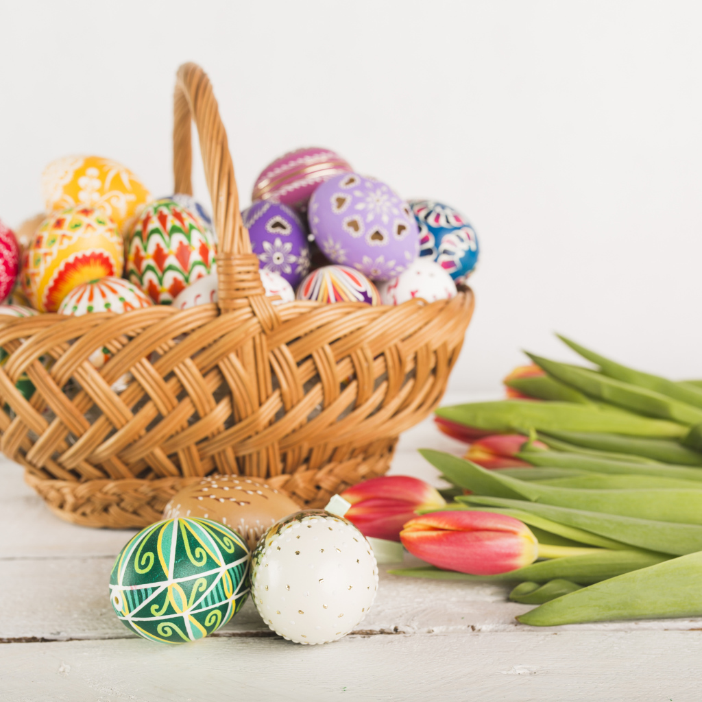 Корзинка с разноцветными яйцами и тюльпанами на Светлый праздник Пасха