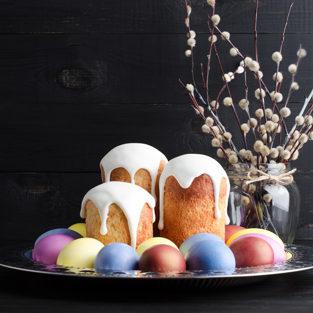 Вкусные куличи на подносе с яйцами и ветками вербы на Пасху