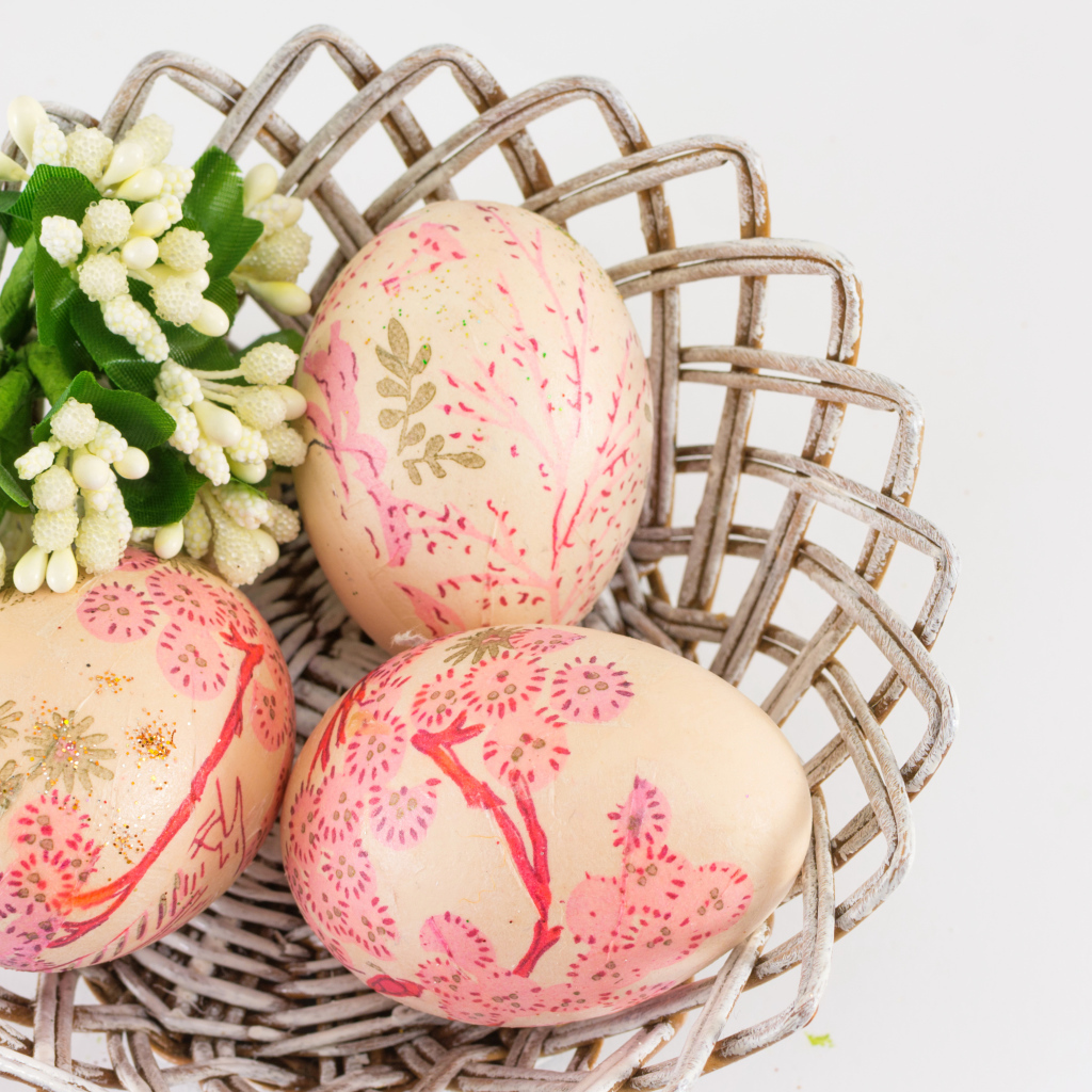 Яйца с рисунком в корзине с цветами на Пасху