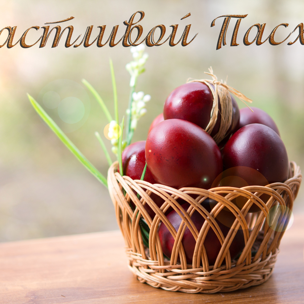 Красные крашеные яйца в корзине, открытка с надписью Счастливой Пасхи