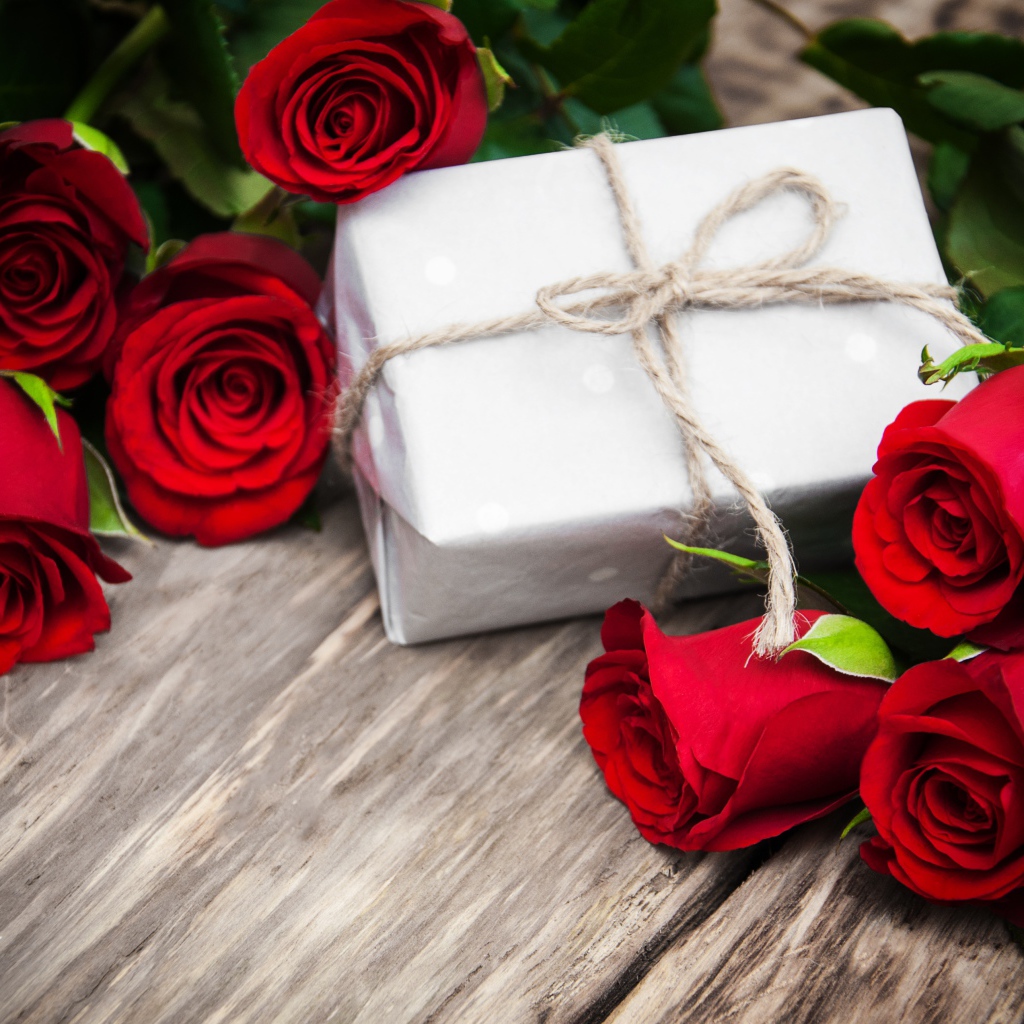 Букет красных роз на столе с подарком на 8 марта