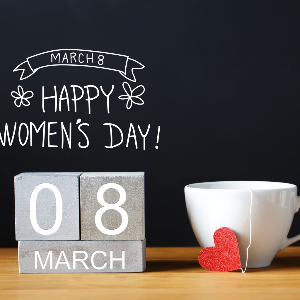 Чашка чая на столе с кубиками на Международный женский день 8 марта