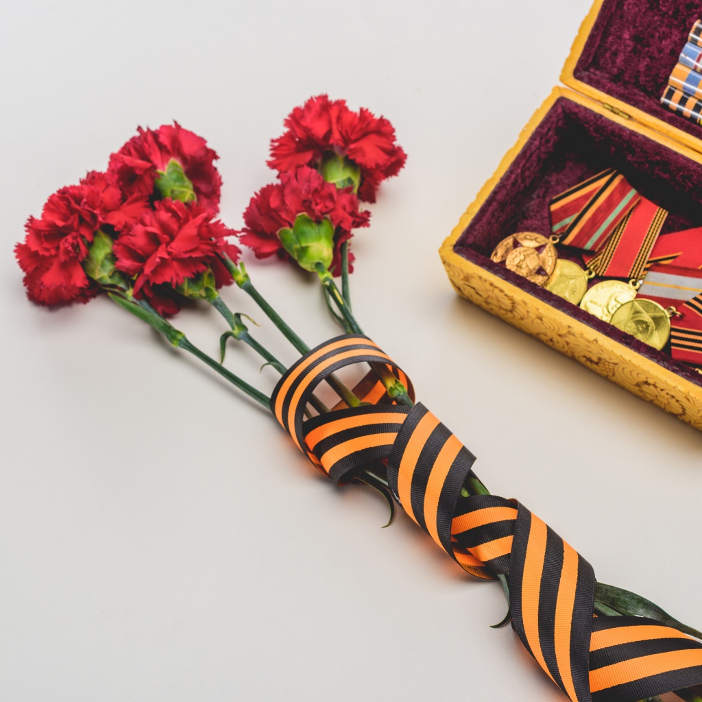 Букет гвоздик с георгиевской лентой и наградами на День Победы 9 мая