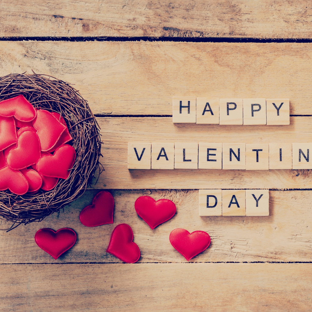 Кубики и гнездо с сердечками на деревянном столе на День Святого Валентина