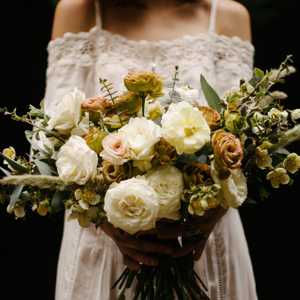 Beautiful bridal bouquet with white roses in hands