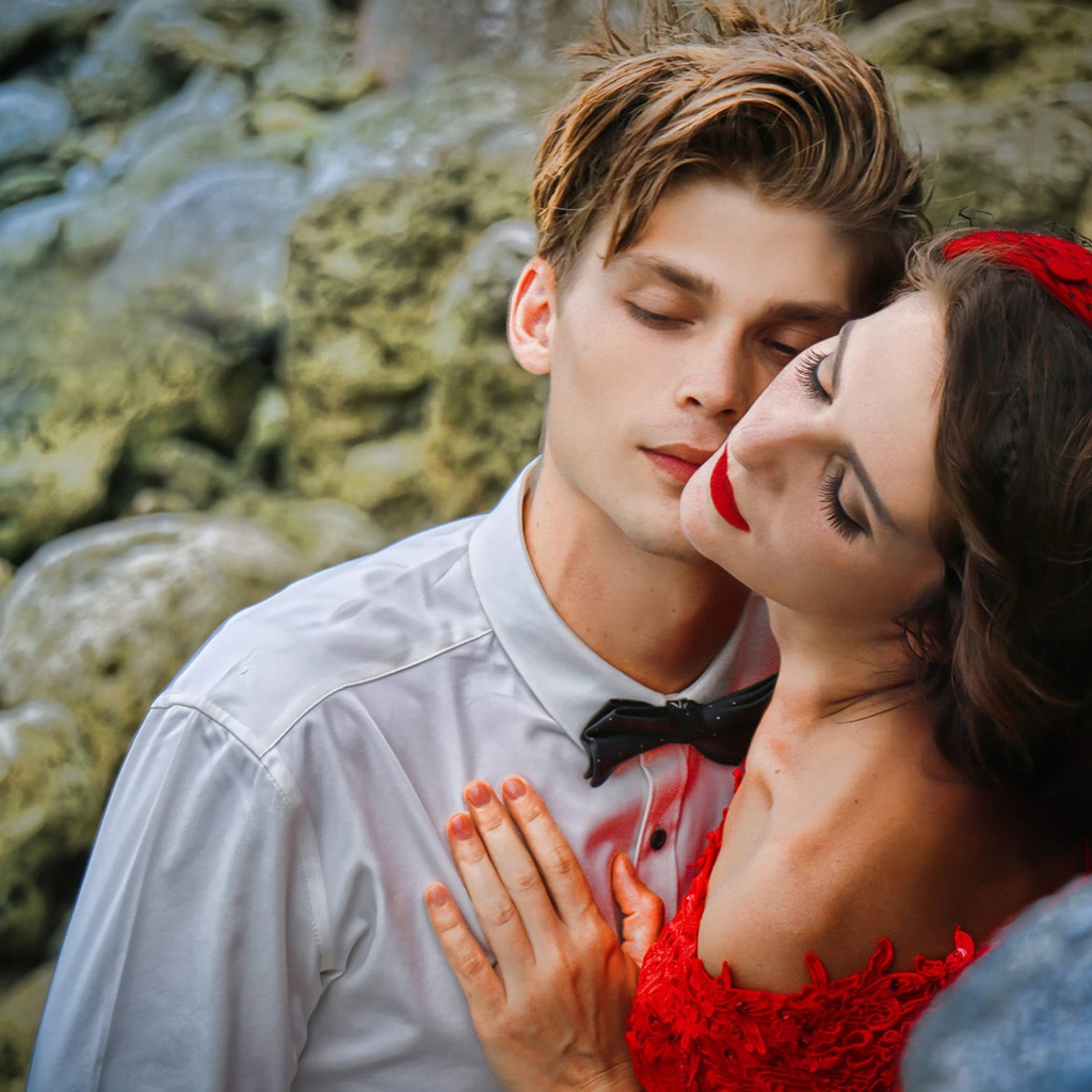 Красивая влюбленная пара стоит у камней