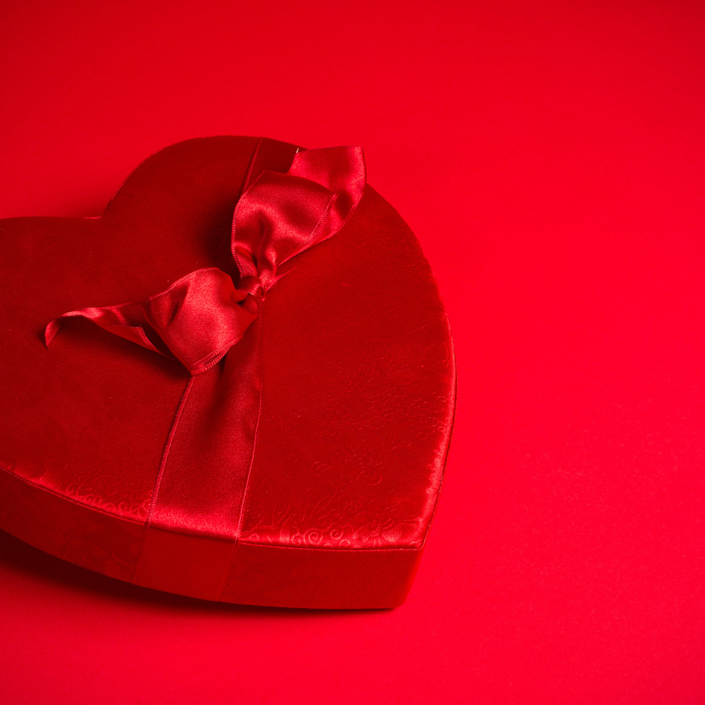 Большое красное сердце с бантом на красном фоне