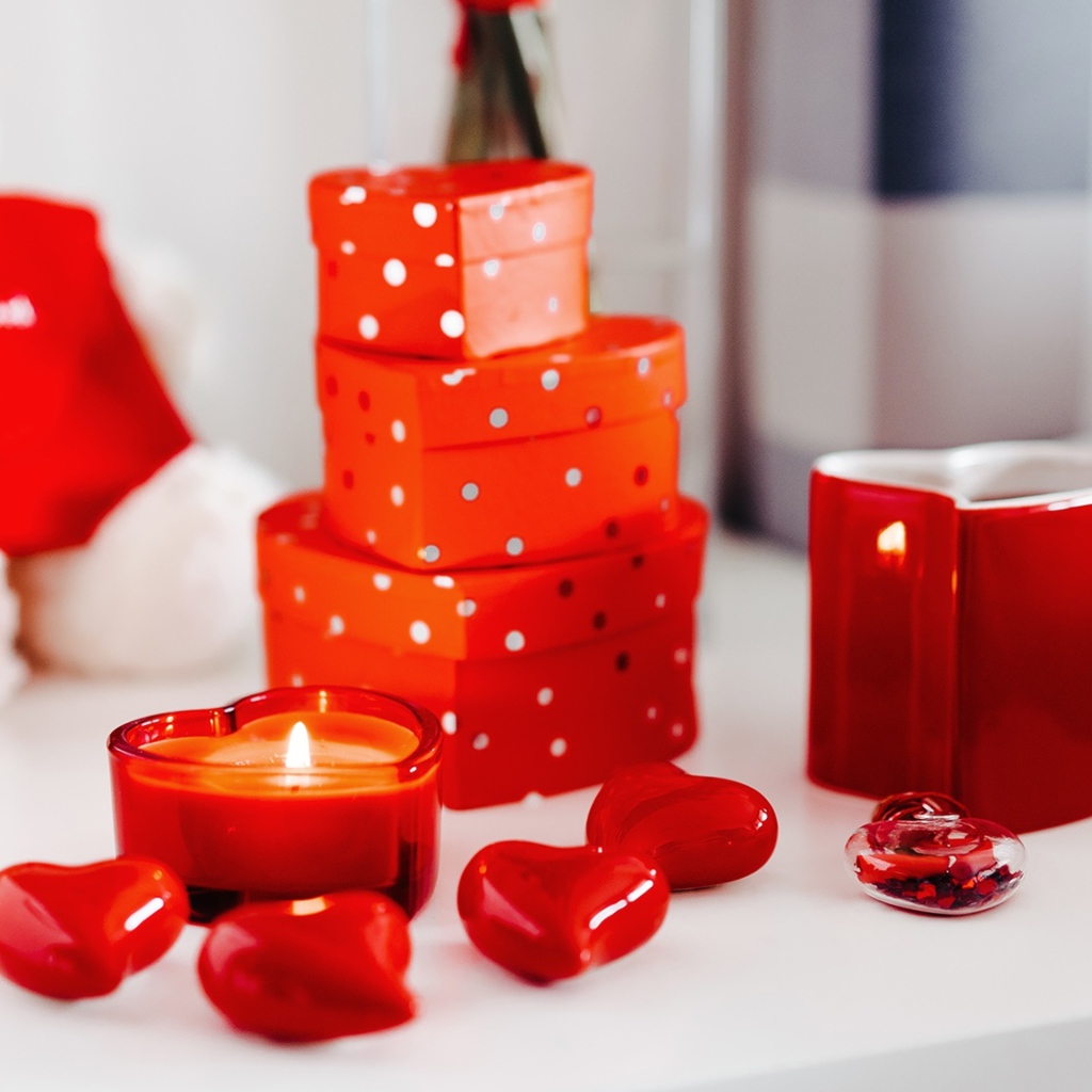 Чашка кофе на столе с подарками, зажженными свечами и сердечками