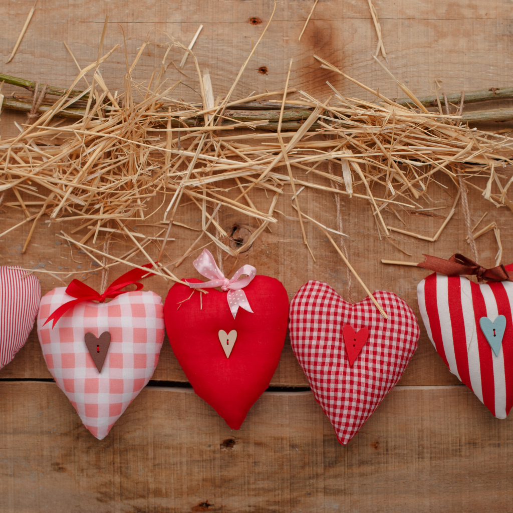 Тканевые сердечки на столе с сеном и веткой