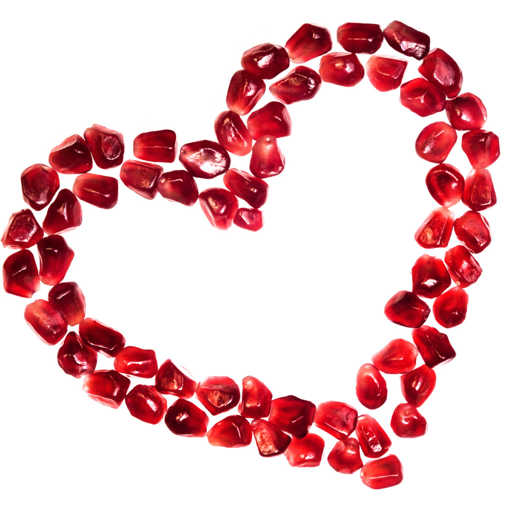 Сердце из гранатовых зерен на белом фоне