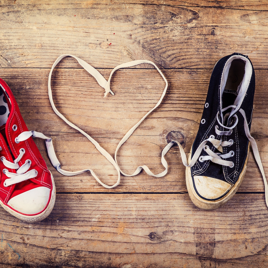 Heart made of laces gumshoes on a wooden table