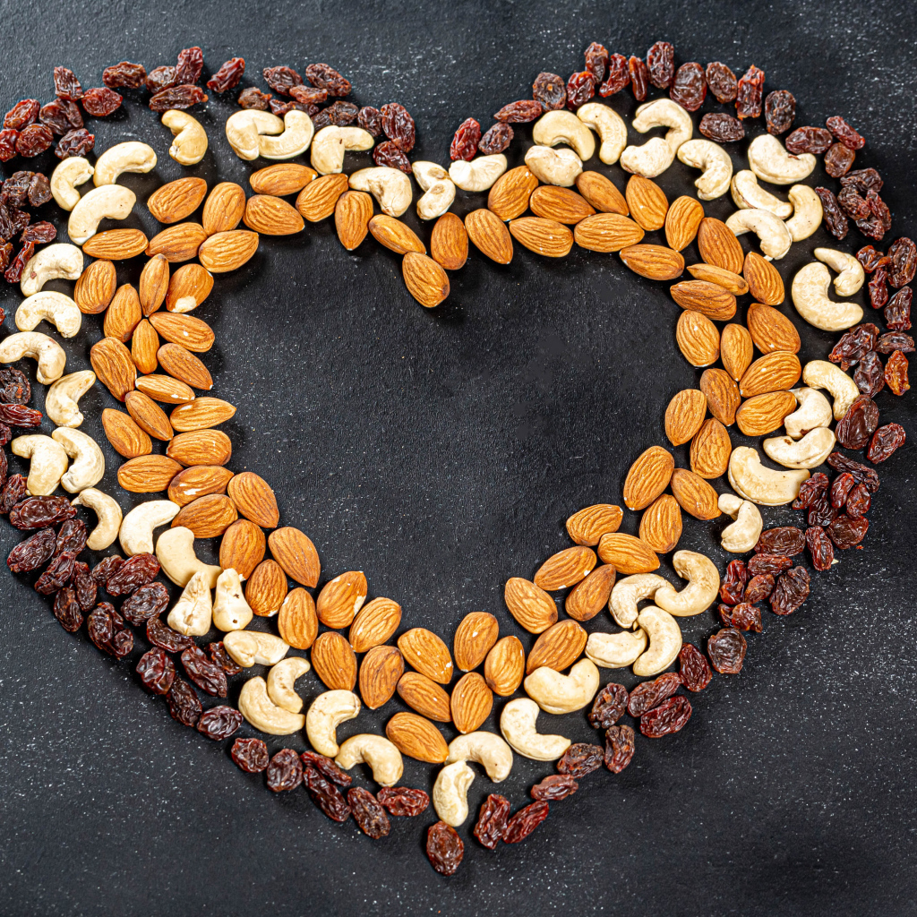 Сердце из орехов и изюма на сером фоне