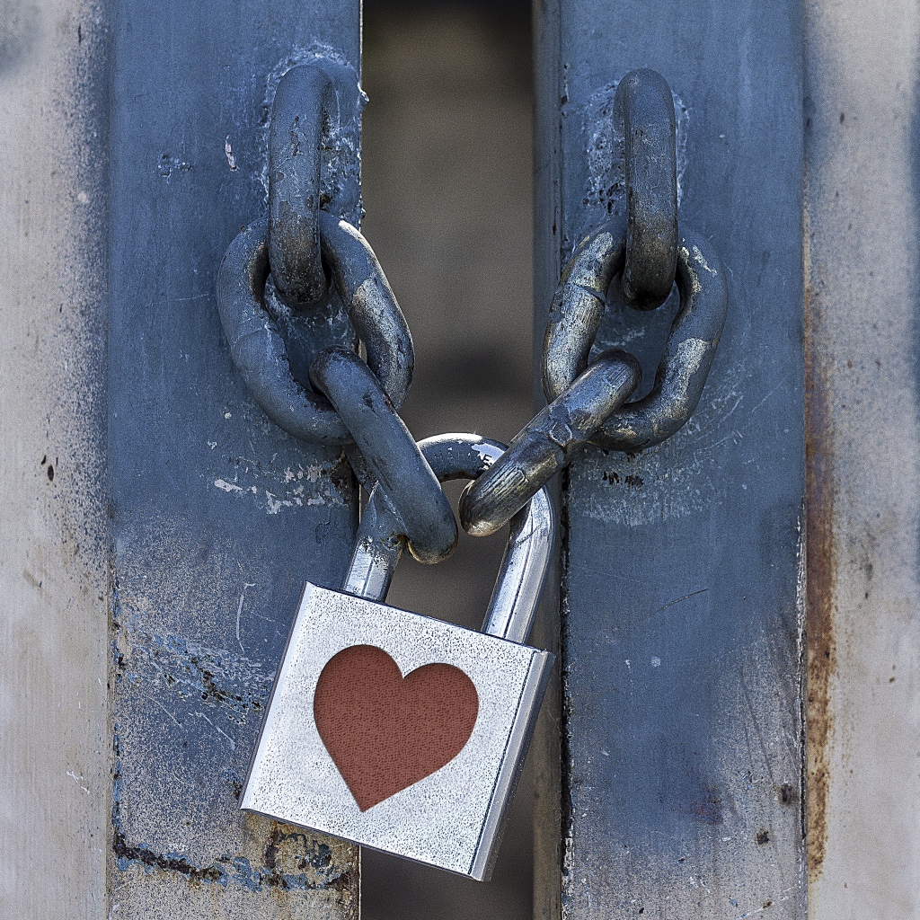 Железный замок с сердцем висит на цепи 