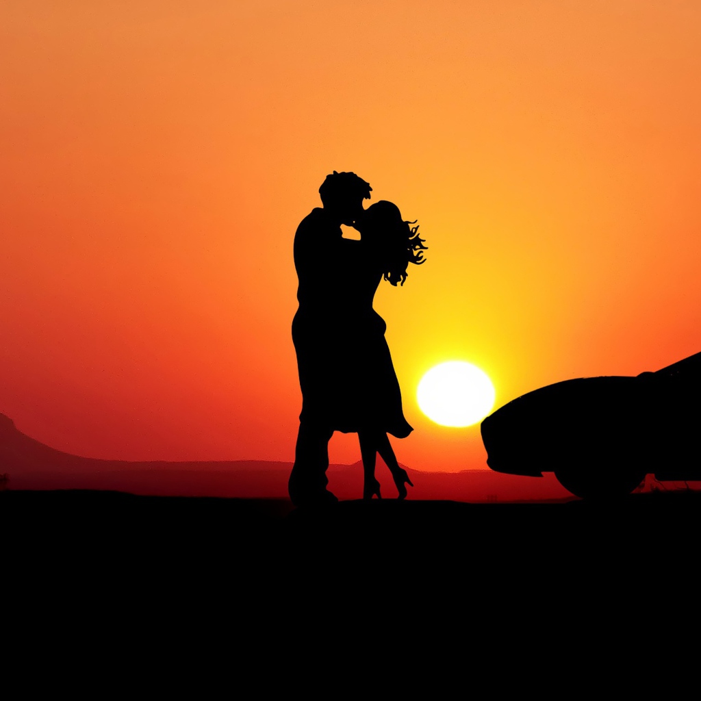 Целующаяся пара на фоне заката с автомобилем