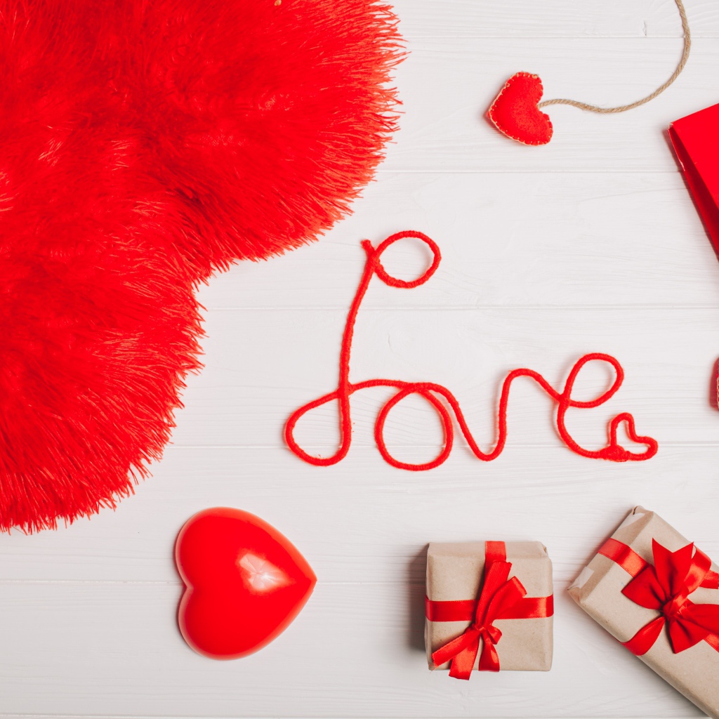 Большая подушка в форме сердца на столе с подарками 