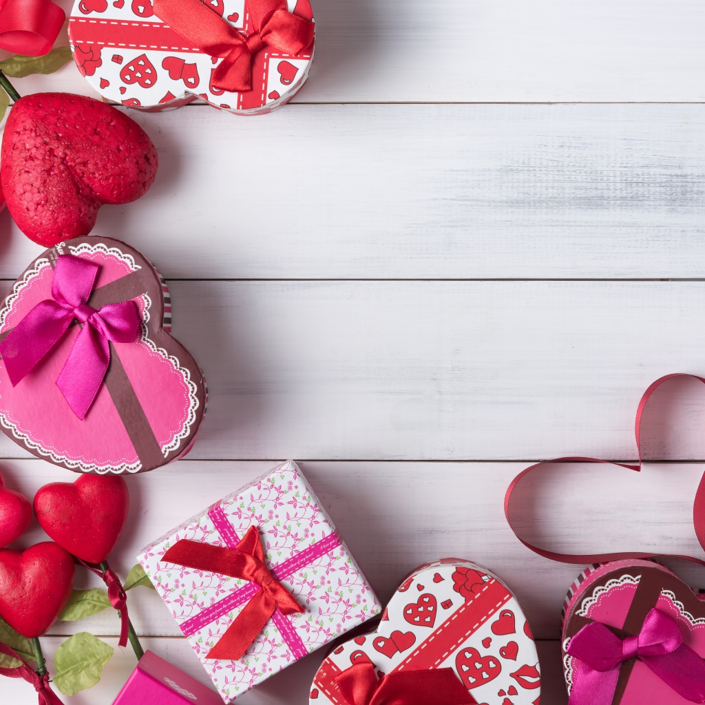 Много подарочных коробок в форме сердца на сером столе 