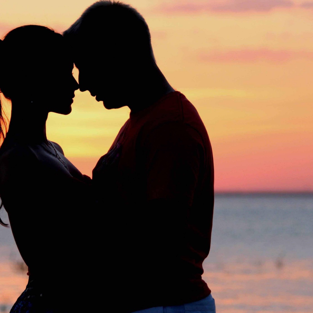 Влюбленная пара на фоне моря в сумерках 