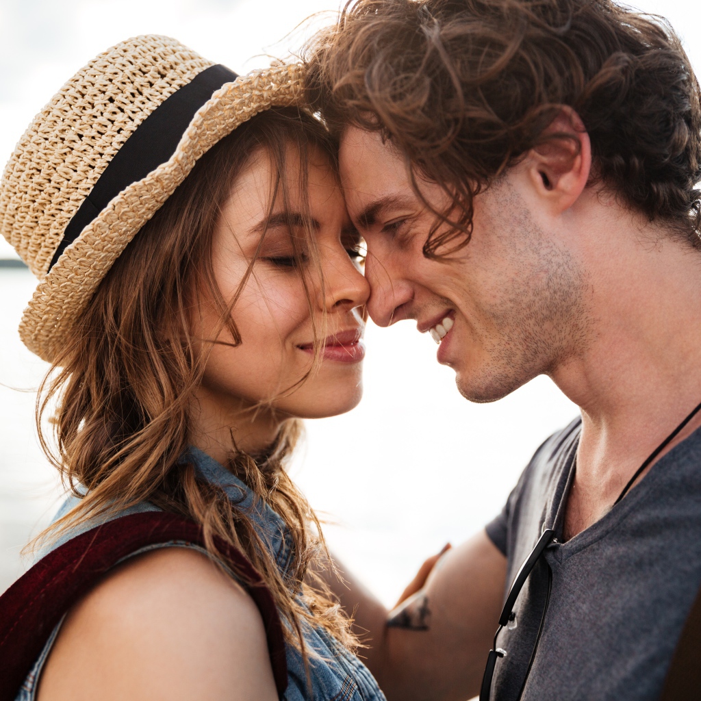 Влюбленная пара стоит на фоне моря 