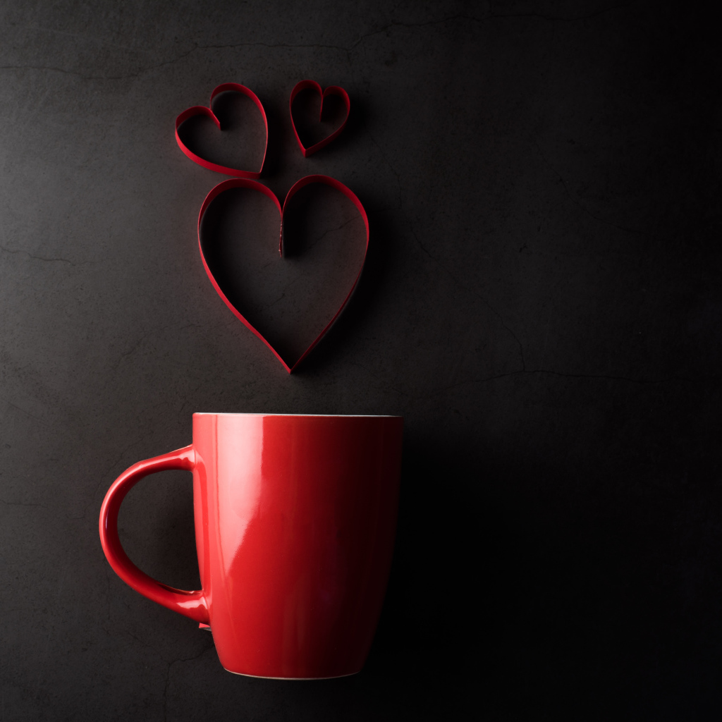 Красная чашка на сером фоне с сердечками