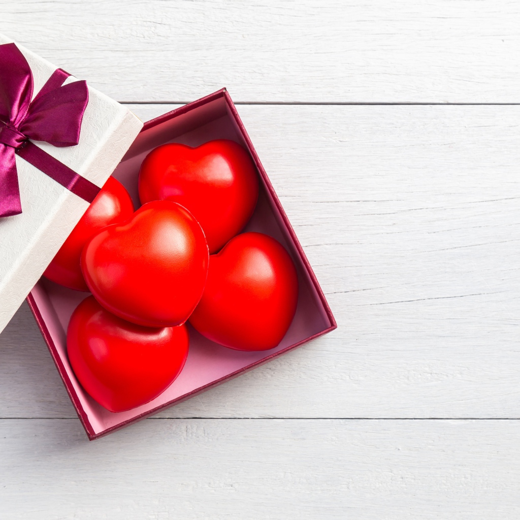 Красные сердечки в коробке на сером фоне