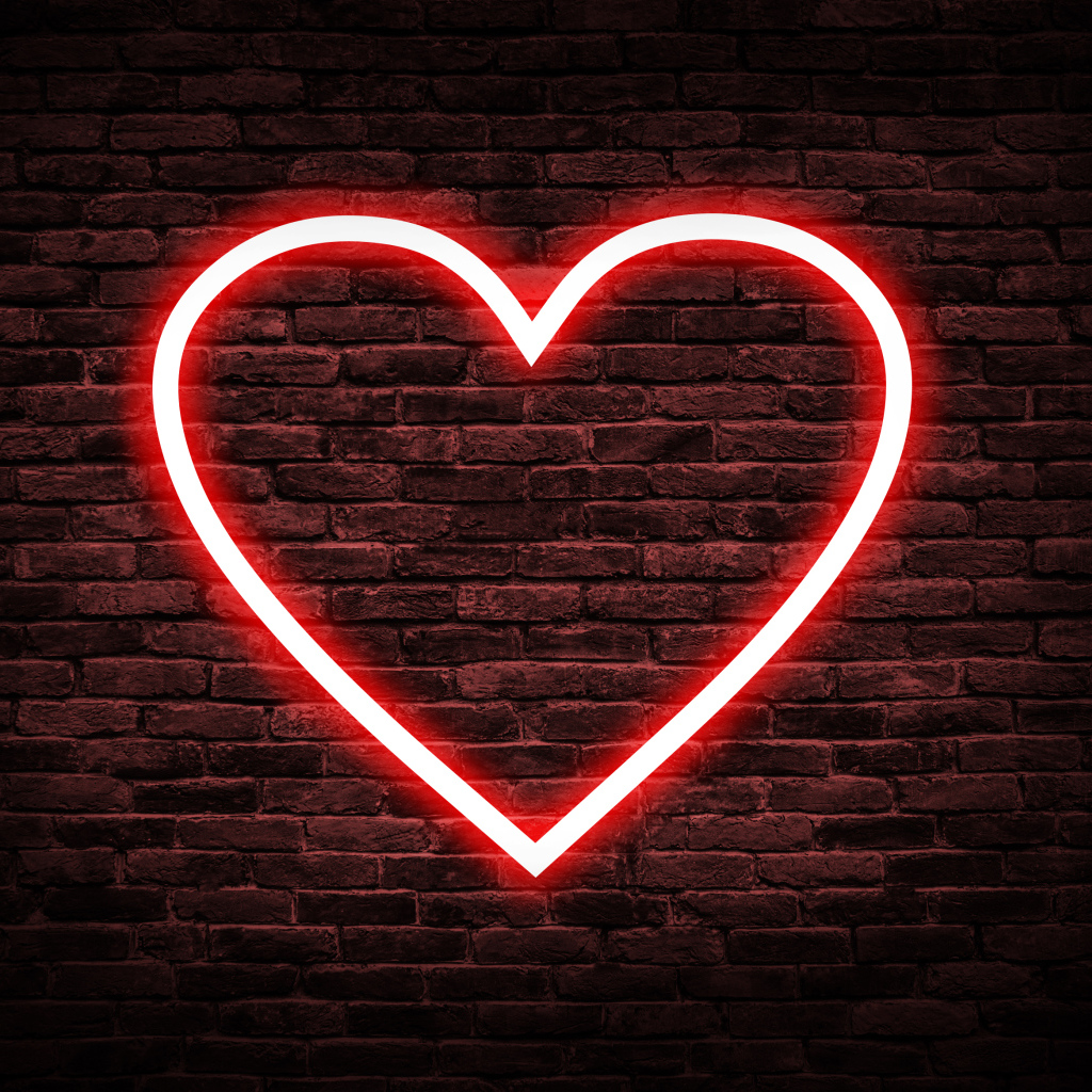 Red neon heart on a brick wall