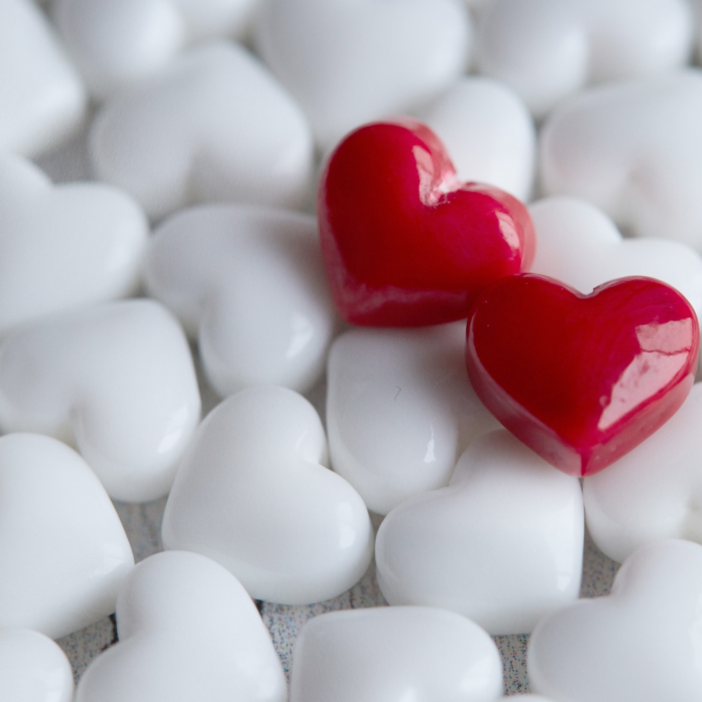 Два красных сердца лежат на белых 