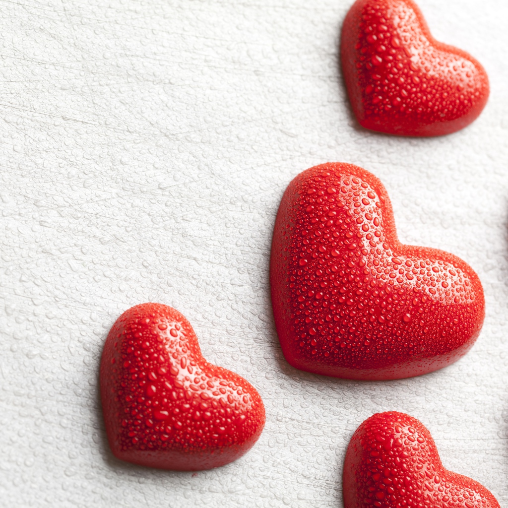 Мокрые красные сердечки на белом фоне