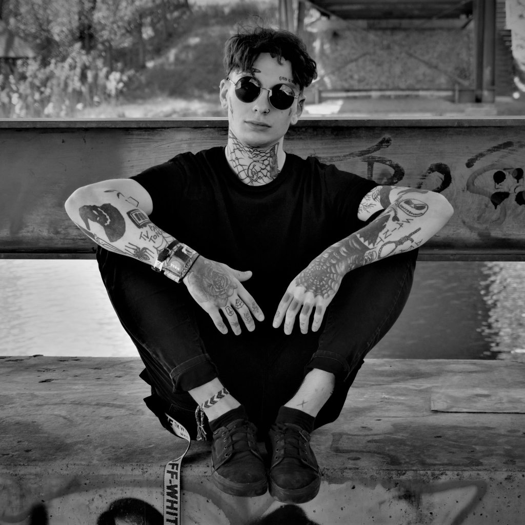 Мужчина в черных очках с татуировками на теле 