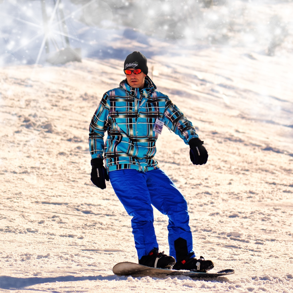 Мужчина сноубордист съезжает с горы 