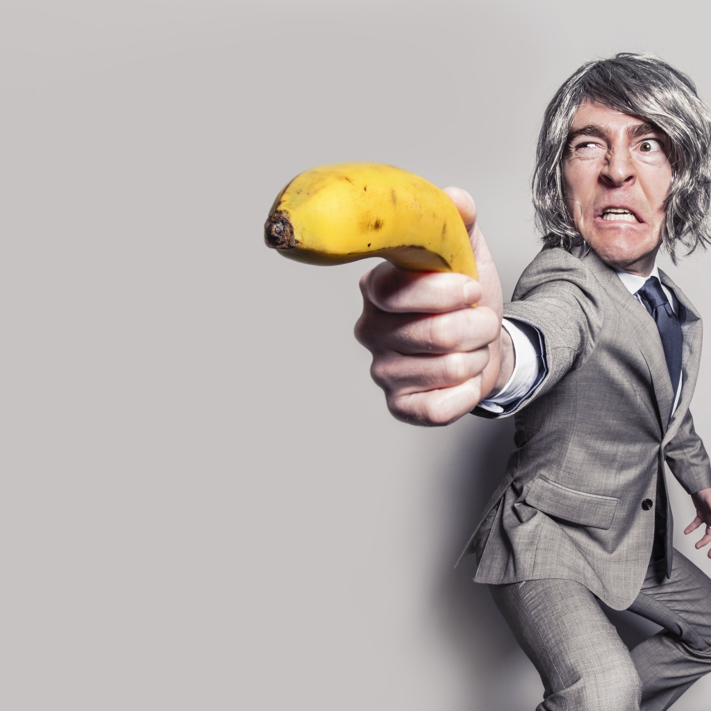 Мужчина в костюме защищается бананом