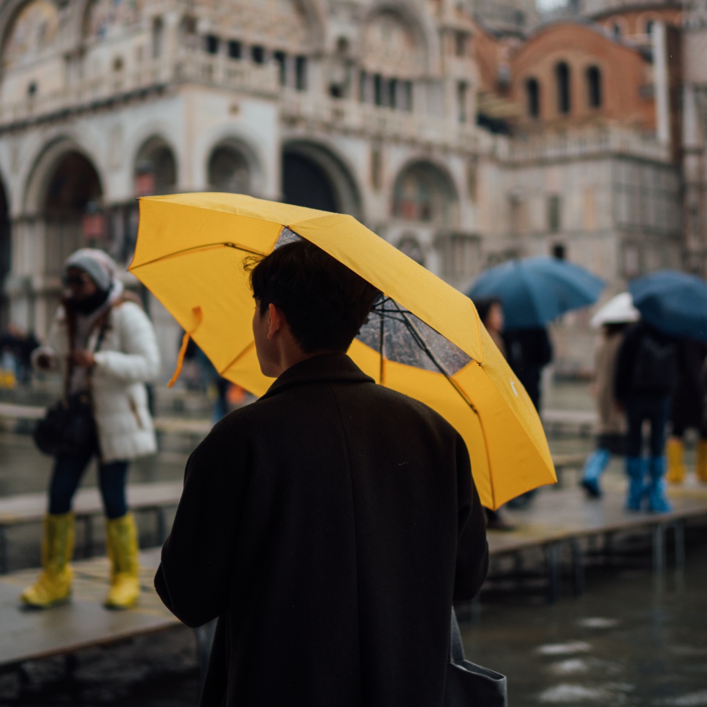 Мужчина с желтым зонтом в городе 