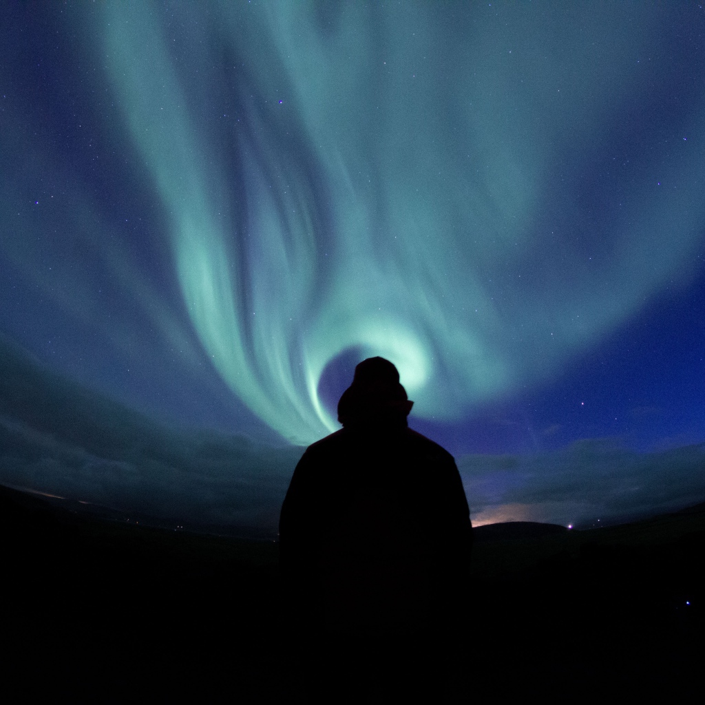 Силуэт мужчины на фоне неба с полярным сиянием