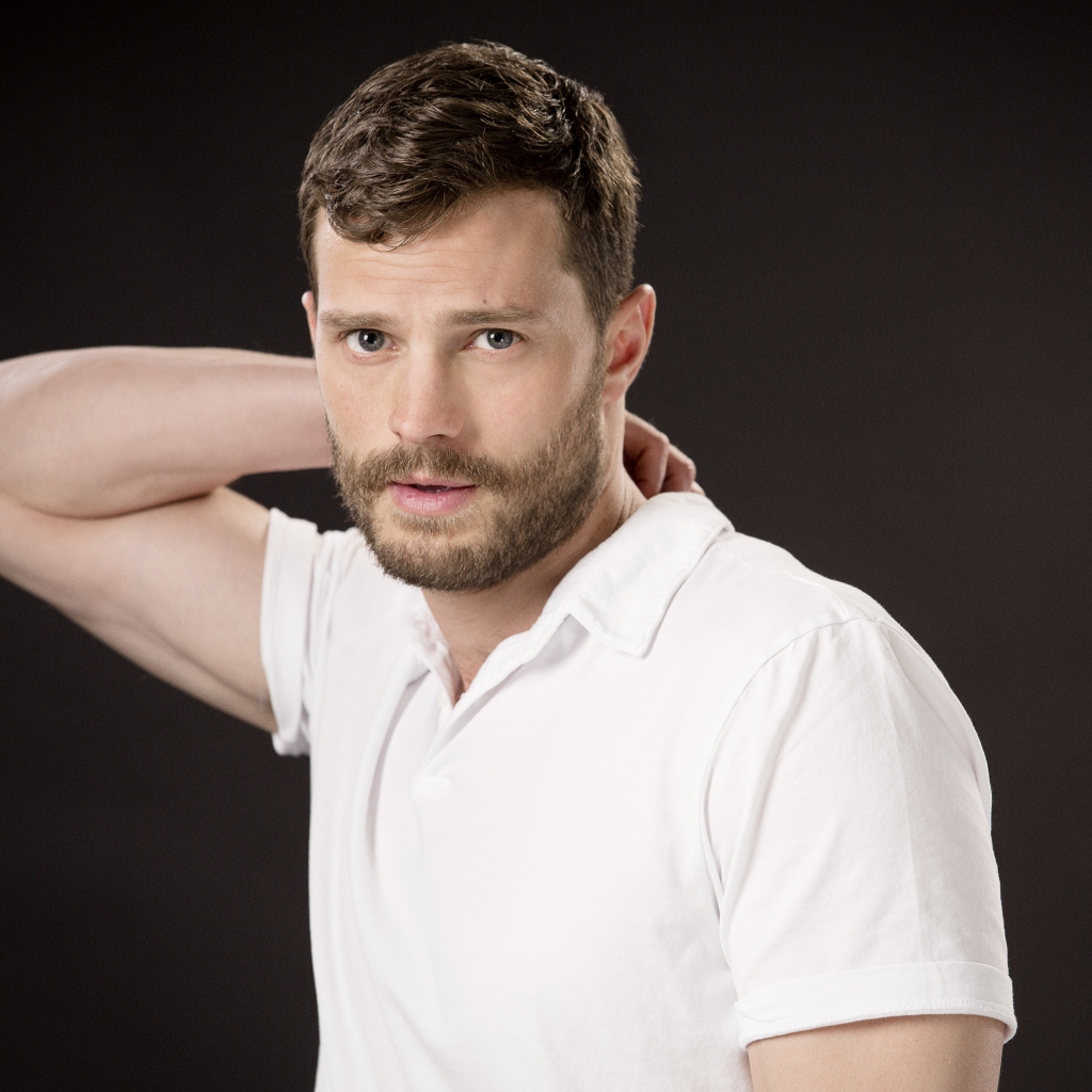 Актер Джейми Дорнан в белой рубашке на коричневом фоне