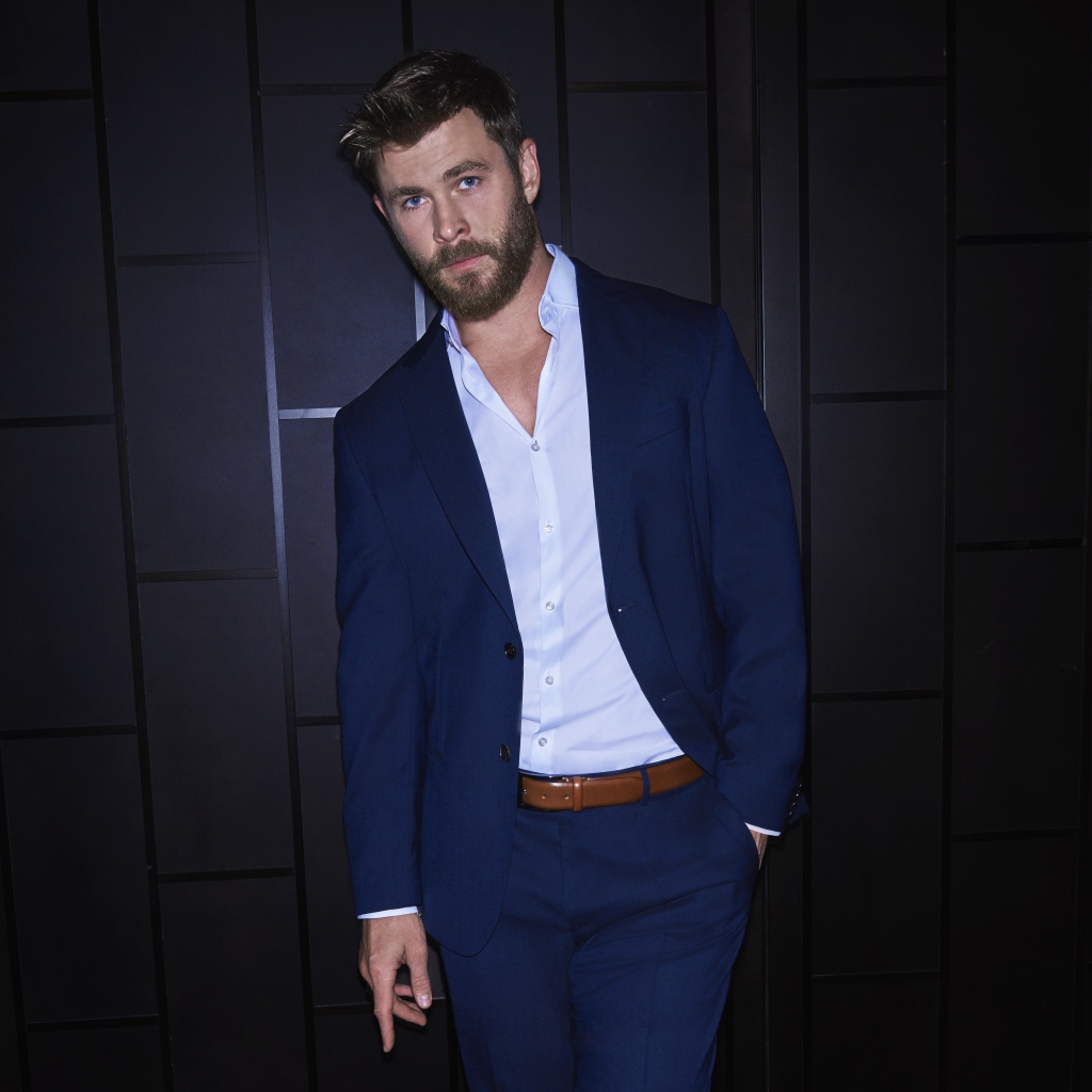 Австралийский актер Крис Хемсворт в костюме у стены