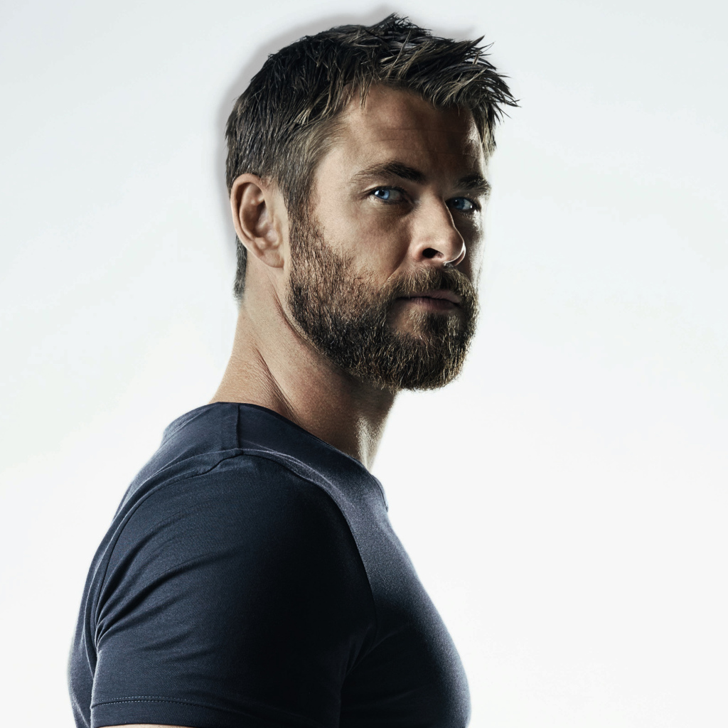 Красивый популярный актер Крис Хемсворт на сером фоне