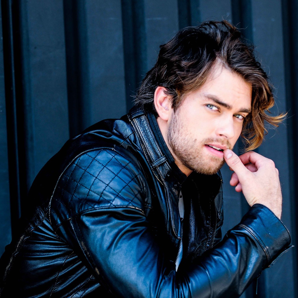 Красивый мужчина, актер Пирсон Фоде в черной кожаной куртке