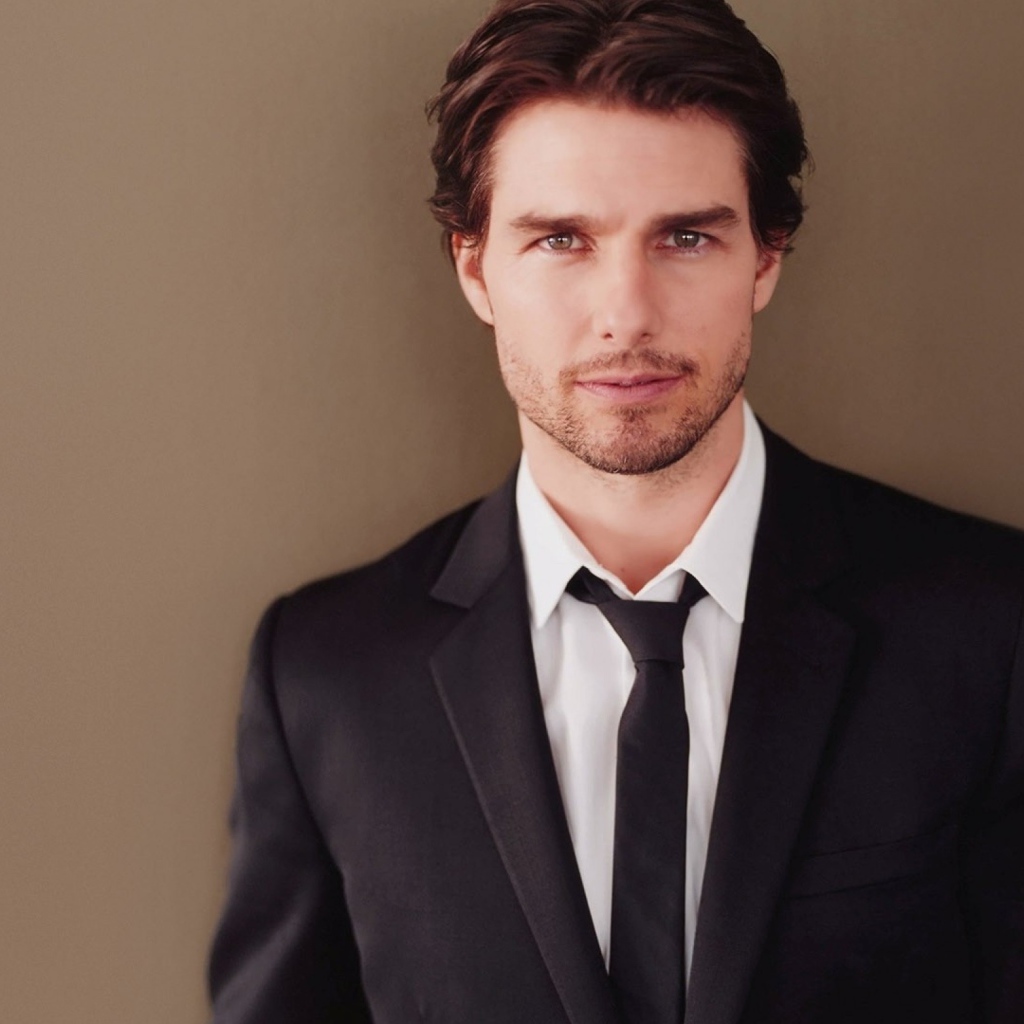 Популярный актер Том Круз в костюме на коричневом фоне